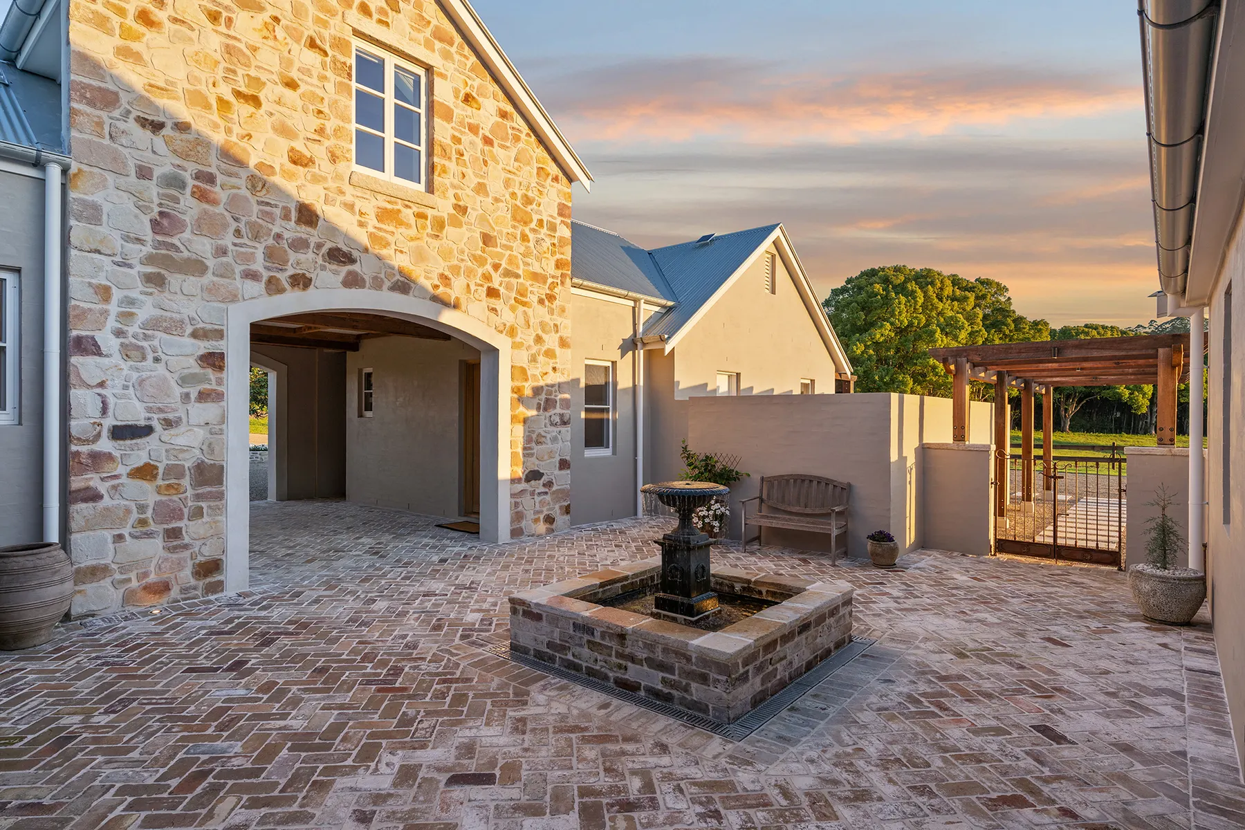 Stone courtyard and fountain built by SaltyDog Landscaping at dusk