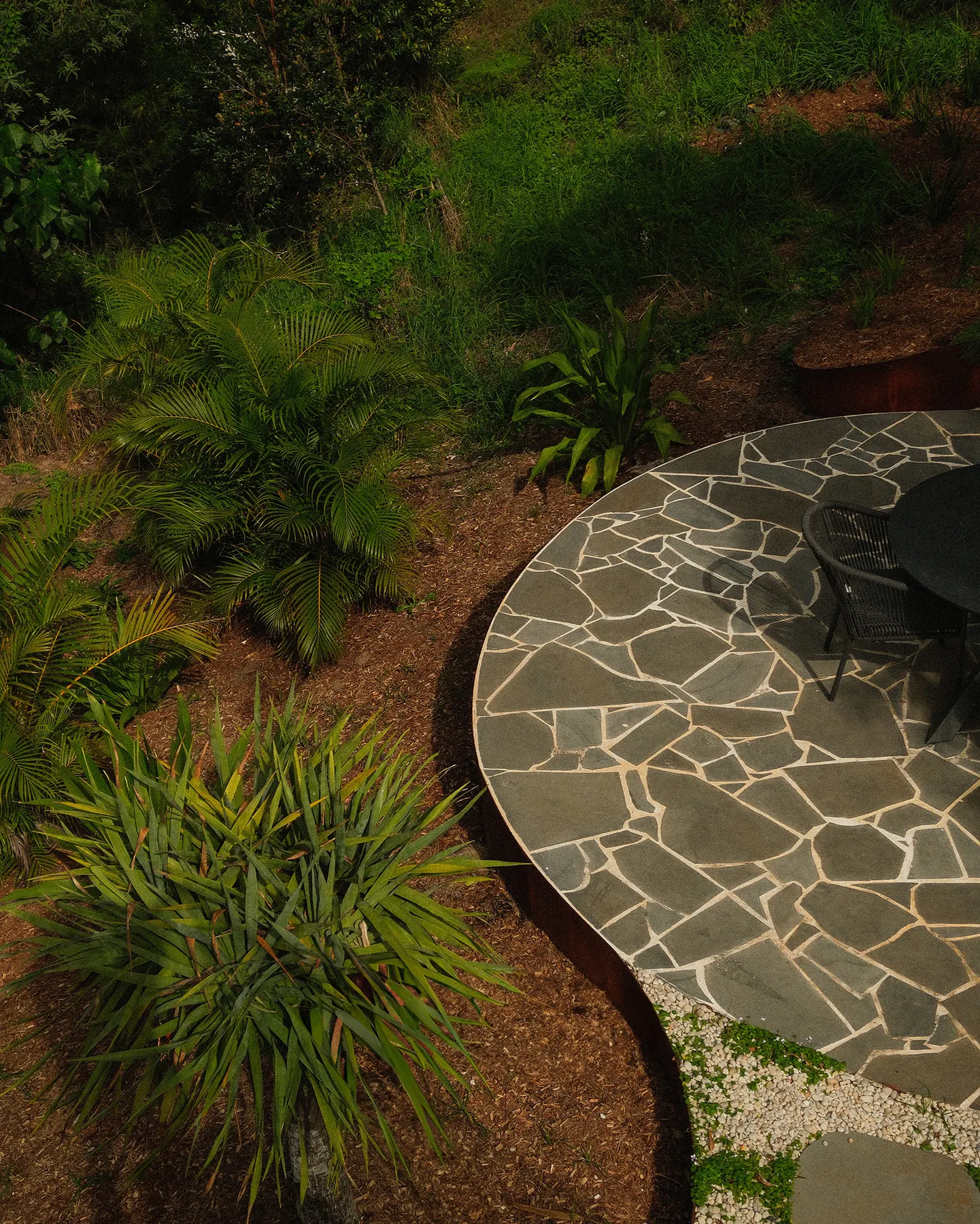 Circular crazy paving patio set amongst native grasses